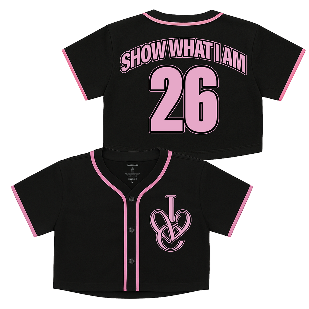 Black short-sleeve baseball-style crop top shown from the front and back. The front has an interlocking 'IVE' logo on the left chest, and the back has pink lettering reading 'SHOW WHAT I AM' and the number '26' outlined in black.