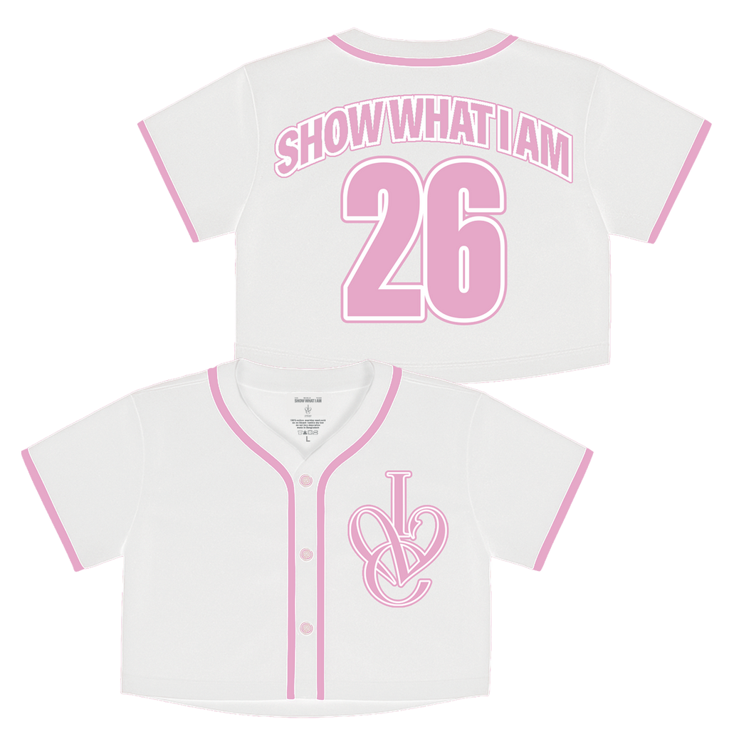 White short-sleeve baseball-style crop top shown from the front and back. The front has pink trim and center buttons, and features an interlocking 'IVE' logo on the left chest. The back has pink trim, arched text reading 'SHOW WHAT I AM', and large number '26' in pink.