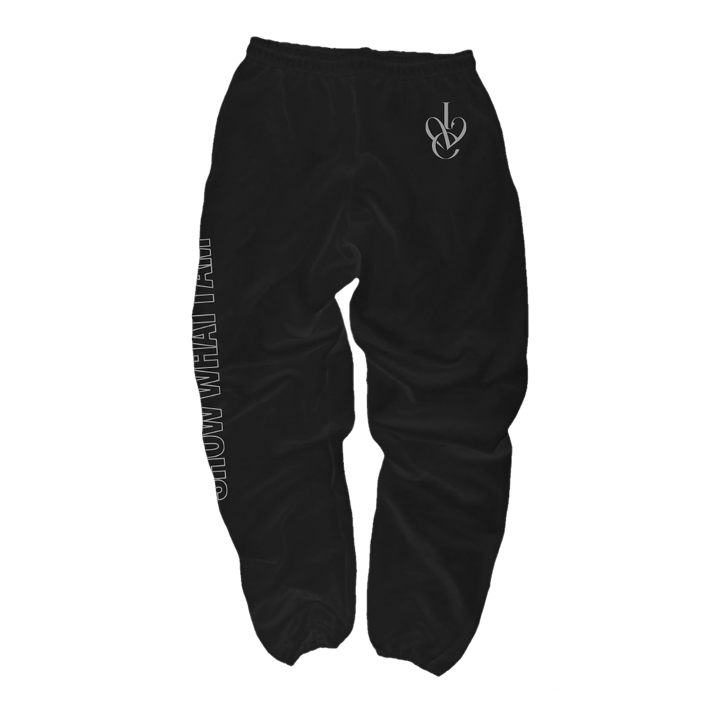 Black sweatpants with a white stylized 'IVE' logo on the upper left hip and vertical white text running down the right leg that says 'SHOW WHAT I AM'.