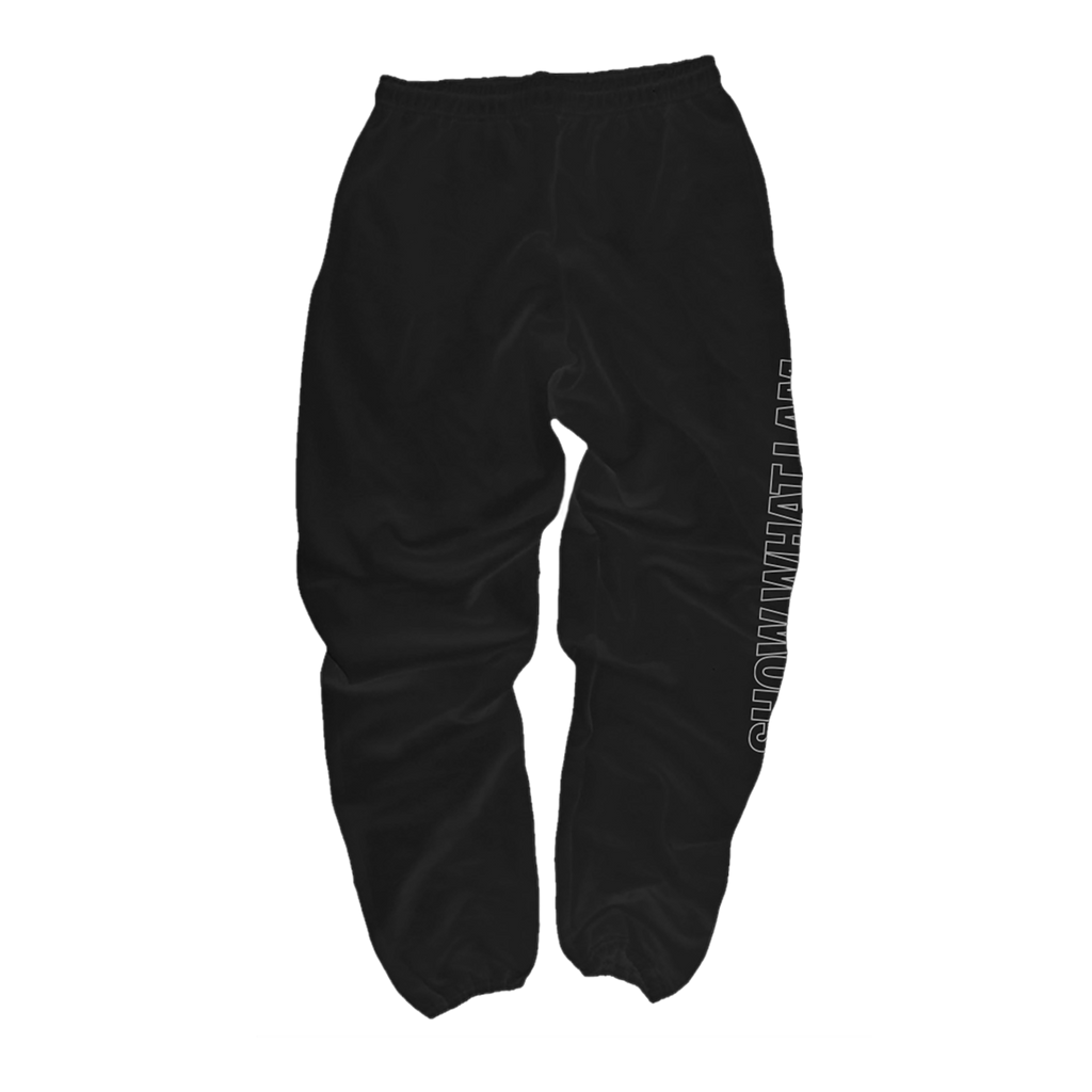 Black sweatpants with a white vertical graphic text print on the right leg that says 'SHOW WHAT I AM', shown from the back.