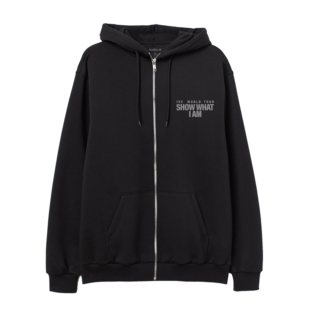 A black zip-up hoodie with a silver zipper, featuring a white graphic text print on the left chest that reads 'IVE WORLD TOUR SHOW WHAT I AM'. The hoodie has a front kangaroo pocket and drawstrings.