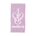 A light pink beach towel featuring a white interlocking graphic of the letters 'IVE' forming a heart, with the text 'IVE WORLD TOUR SHOW WHAT I AM' printed below in white.