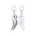 A silver angel wing keychain with front and back shown side by side, one with a polished finish and the other engraved with the text 'IVE WORLD TOUR SHOW WHAT I AM'.